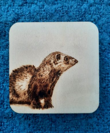 Een gebrandschilderde bunzing op een klein houten paneeltje van 8 x 8